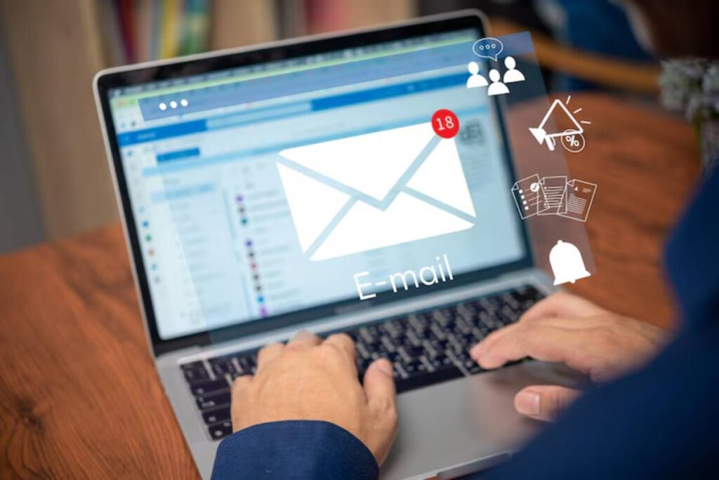 A person types on a laptop with an email interface visible, showing 18 new messages and various notification icons.