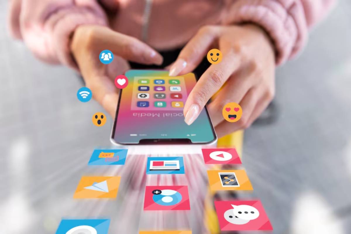 A person interacts with a smartphone displaying colorful app icons, surrounded by emojis representing social media and communication.