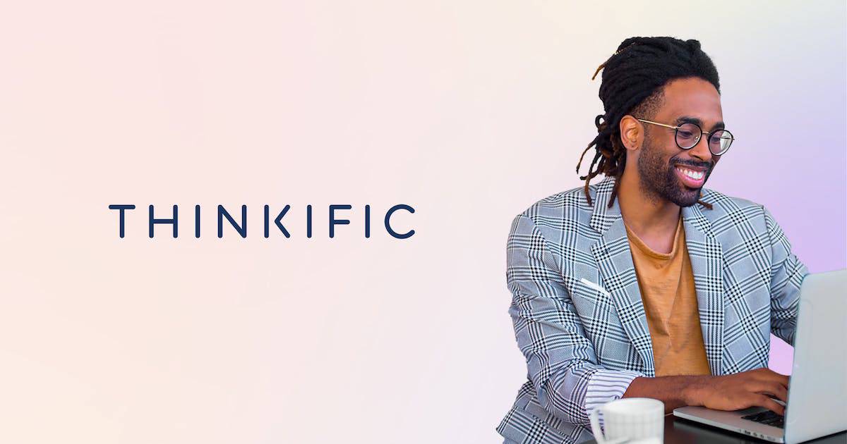 A person in a checked blazer and mustard shirt works on a laptop at a desk with a coffee cup, beside the Thinkific logo.